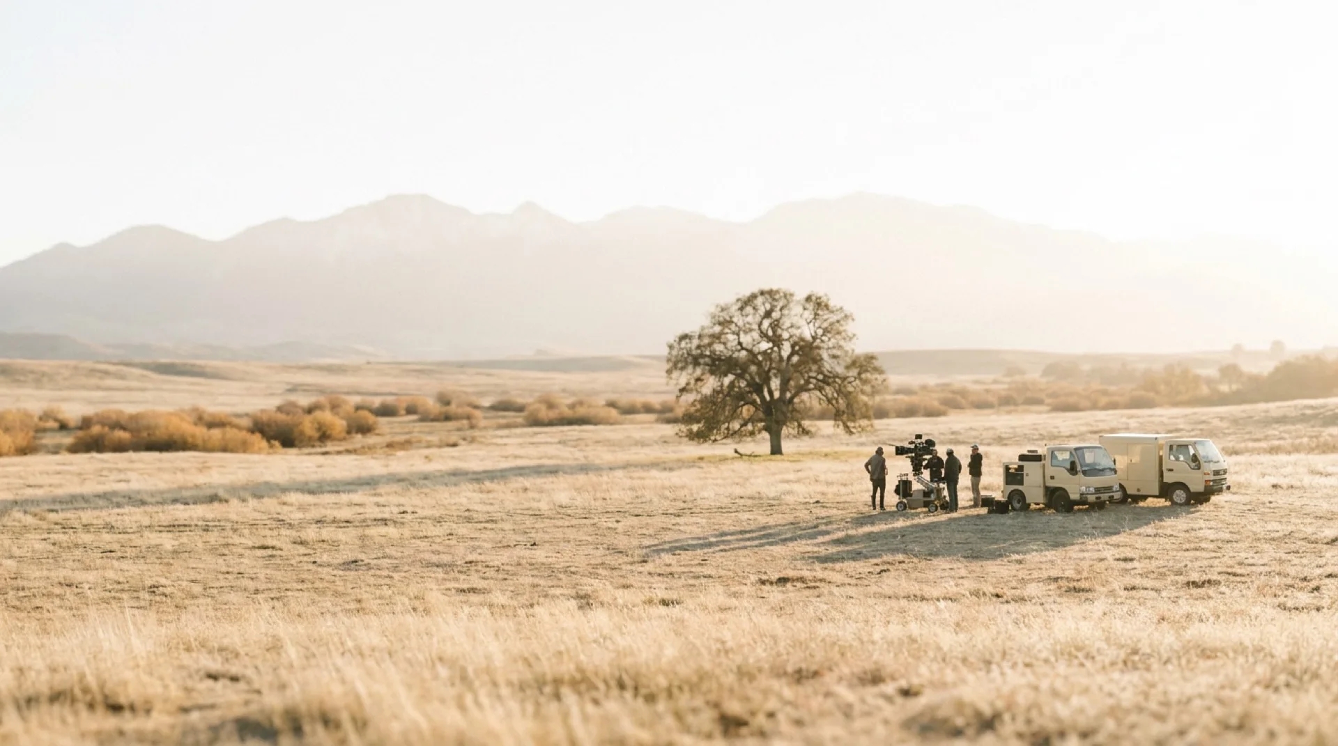 A small film crew far out in a golden valley at the end of a shoot day